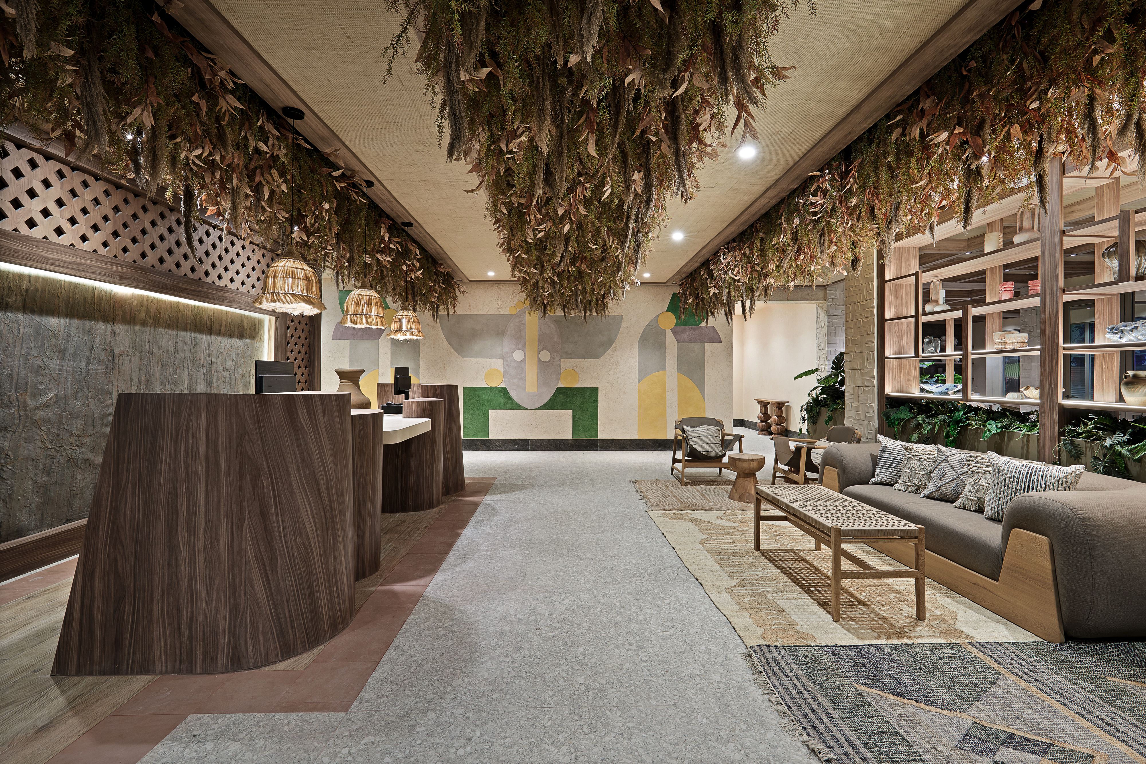 Hotel lobby with wood accents, woven lighting, greenery, and lounge seating